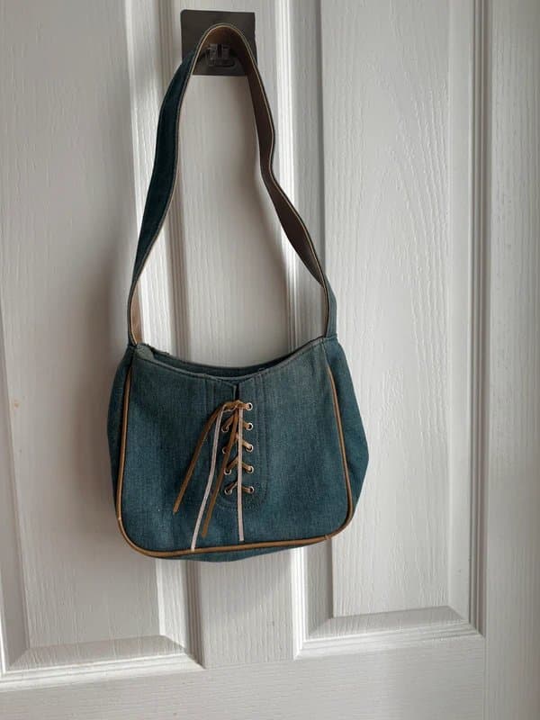 Vintage Dressing Y2K-style denim shoulder bag featuring a lace-up detail and contrast faux leather trim