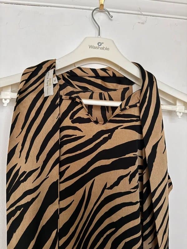Never Fully Dressed Never Fully Dressed silky halter top features a zebra print pattern and a tied neckline