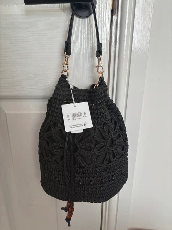 New Look Black woven bucket bag, floral crochet detail, drawstring closure. New with tags.