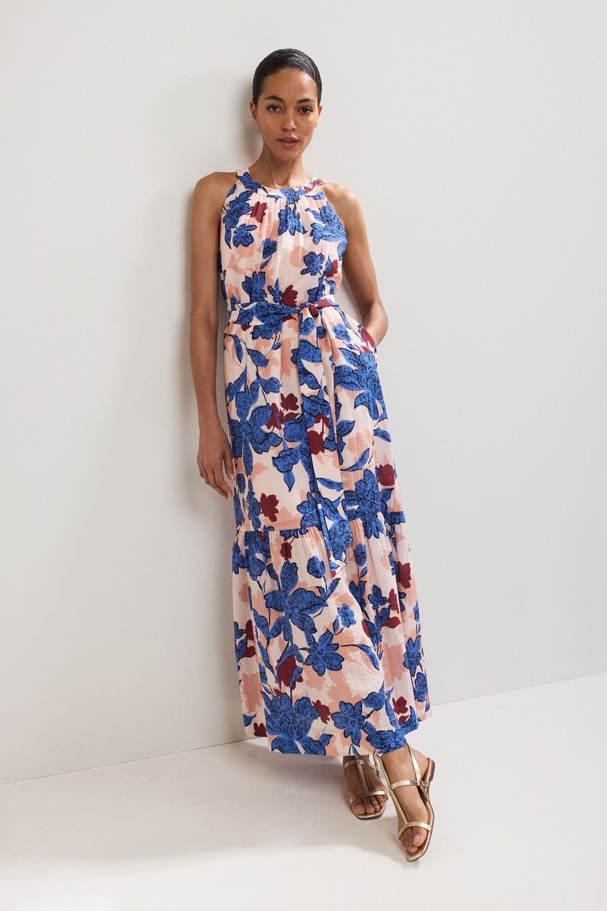 Phase Eight Runa halter-neck tiered maxi dress in a blush and cobalt studio floral print — the brand's signature wedding-guest look